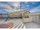 The backyard features a covered patio area with a built-in grill and an adjacent playground set at 1113 Date St, Las Vegas, NV 89108