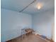 A small storage area with concrete flooring, a light fixture, and paint cans against a blue wall at 1113 Date St, Las Vegas, NV 89108