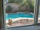 View of a refreshing in-ground pool with rock details and mature landscaping at 1297 Peppercorn Ave, Henderson, NV 89012