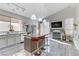 Modern kitchen with stainless steel appliances, kitchen island with barstool seating, and a cozy fireplace at 139 Serenade Ct, Henderson, NV 89074