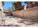The backyard features a tall brick wall and dirt area with a partial patio at 1457 Summer Glow Ave, Henderson, NV 89012