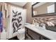 This bathroom features a single sink vanity and a shower with a patterned curtain at 1457 Summer Glow Ave, Henderson, NV 89012