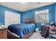 This is a blue bedroom with a large window, dark-wood furniture, and clutter at 1457 Summer Glow Ave, Henderson, NV 89012