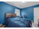 This blue bedroom includes a large window, neutral carpet, and dark wood furnishings at 1457 Summer Glow Ave, Henderson, NV 89012