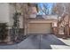 A two-car garage with a large driveway and desert landscaping located at the front of the home at 1457 Summer Glow Ave, Henderson, NV 89012