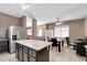 Open-concept kitchen features a center island, stainless steel appliances, and a dining area at 1457 Summer Glow Ave, Henderson, NV 89012