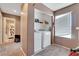 Functional laundry room with modern appliances and shelving, conveniently located near the bathroom at 1457 Summer Glow Ave, Henderson, NV 89012