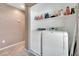 Well-lit laundry area featuring a modern washer and dryer with storage shelving at 1457 Summer Glow Ave, Henderson, NV 89012