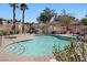 Community pool with clear blue water, palm trees, and a shaded lounge area at 1457 Summer Glow Ave, Henderson, NV 89012