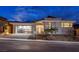 Stunning modern home with a stylish stone facade, a glass garage door, and professionally landscaped yard at 148 Tre Pietre St, Henderson, NV 89011