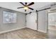 Well lit bedroom with light walls, barn door access, modern ceiling fan, and wood floor at 1906 Palora Ave, Las Vegas, NV 89169