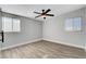 Bright bedroom with wood-look flooring, a ceiling fan, and natural light at 1906 Palora Ave, Las Vegas, NV 89169