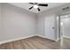 A spacious bedroom with wood floors, a ceiling fan, and a white door at 1906 Palora Ave, Las Vegas, NV 89169