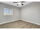 Well lit bedroom with light walls, modern ceiling fan, wood floor, and window at 1906 Palora Ave, Las Vegas, NV 89169