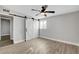 Bedroom featuring barn doors, ceiling fan, and wood-look flooring at 1906 Palora Ave, Las Vegas, NV 89169