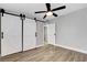 Bedroom features wood floors, a modern ceiling fan and barn door entry to closet or bath at 1906 Palora Ave, Las Vegas, NV 89169