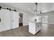 Open living space featuring wood floors, barn doors, and a modern island with bar seating at 1906 Palora Ave, Las Vegas, NV 89169