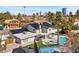 An elevated view showcasing the home's layout, pool, sports court and surrounding greenery and city views at 1912 Calanda Ct, Las Vegas, NV 89102