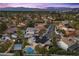 An elevated view of a home with a pool and sports court, surrounded by palm trees in a suburban neighborhood at 1912 Calanda Ct, Las Vegas, NV 89102