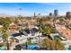 Elevated view of a luxurious home surrounded by lush landscaping, pool, and city views at 1912 Calanda Ct, Las Vegas, NV 89102