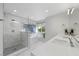 Bright bathroom features a glass shower, soaking tub, double vanity with modern fixtures and white marble accents at 1912 Calanda Ct, Las Vegas, NV 89102