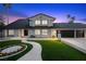 Home exterior showcasing a well-manicured lawn and a three-car garage at dusk at 1912 Calanda Ct, Las Vegas, NV 89102