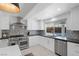 A well-lit kitchen features stainless steel appliances, light-colored cabinets, and a window overlooking the pool area at 1912 Calanda Ct, Las Vegas, NV 89102