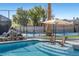 Poolside view with spa and lounging area beside tennis court and waterfall feature at 1912 Calanda Ct, Las Vegas, NV 89102