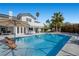 Beautiful backyard pool with patio, lounge chairs, palm trees, and landscaped area for relaxing and entertaining at 1912 Calanda Ct, Las Vegas, NV 89102