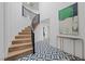 An elegant curved staircase with wood treads and a black metal railing, with modern geometric tile flooring at 1912 Calanda Ct, Las Vegas, NV 89102
