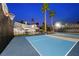 The view of the tennis court at dusk features palm trees, lighting, and a beautiful home at 1912 Calanda Ct, Las Vegas, NV 89102