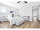 Bedroom with light walls, and wood-look floors featuring ceiling fan and a view into the hallway at 2604 Iron Crest Ln, Las Vegas, NV 89138