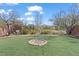Backyard features a rock fire pit, artificial turf, and a privacy fence at 2624 Courlan Dr, North Las Vegas, NV 89084