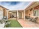 Inviting backyard patio area with covered seating, brick flooring, and artificial turf, ideal for relaxation and outdoor enjoyment at 2735 Poppyseed Way, Las Vegas, NV 89142