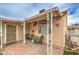 Cozy covered patio area with seating, brick flooring, and decorative lights, perfect for outdoor dining and relaxation at 2735 Poppyseed Way, Las Vegas, NV 89142