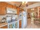 Traditional kitchen with wood cabinets, white appliances, tile floors, and breakfast bar at 2735 Poppyseed Way, Las Vegas, NV 89142