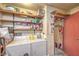 Functional laundry room with washer, dryer, shelving, and storage space for cleaning supplies and household needs at 2735 Poppyseed Way, Las Vegas, NV 89142
