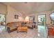 Spacious living room featuring a large sectional sofa, neutral tile flooring, and lots of natural light at 2735 Poppyseed Way, Las Vegas, NV 89142