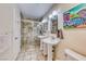 Bright bathroom featuring double pedestal sinks, tiled shower, and neutral wall paint at 2809 Gilmary Ave, Las Vegas, NV 89102
