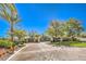 Inviting entrance to a gated community with lush trees, mature landscaping, and brick-paved roads at 2994 San Lorenzo Ct, Henderson, NV 89052