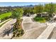 Elegant entrance with a circular driveway, mature trees, and landscaping that leads to a gated community at 2994 San Lorenzo Ct, Henderson, NV 89052