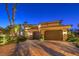 Illuminated two-story home featuring a red tile roof, desert landscaping, and an attached two-car garage at 2994 San Lorenzo Ct, Henderson, NV 89052