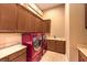 Bright laundry room with modern, red washer and dryer units and ample cabinet space at 2994 San Lorenzo Ct, Henderson, NV 89052