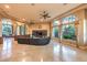 Open living room with a leather sofa, TV, arched windows, and tiled floors at 2994 San Lorenzo Ct, Henderson, NV 89052