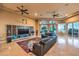 Comfortable living space with a dark leather sectional, ceiling fans, and outdoor views at 2994 San Lorenzo Ct, Henderson, NV 89052