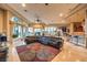 Elegant living room featuring a large leather sectional, an ornate rug, and abundant natural light at 2994 San Lorenzo Ct, Henderson, NV 89052