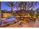 Outdoor kitchen with built-in BBQ, seating, and thatched umbrella at 2994 San Lorenzo Ct, Henderson, NV 89052