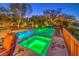Backyard pool and spa with a waterfall feature and colorful LED lighting at dusk at 2994 San Lorenzo Ct, Henderson, NV 89052