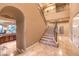 Grand foyer with a curved staircase, detailed iron railings, and views of the kitchen at 2994 San Lorenzo Ct, Henderson, NV 89052