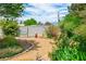 Backyard with gravel and rock landscaping featuring a garden area with mature trees and manicured green plants at 3101 Margarita St, Pahrump, NV 89048